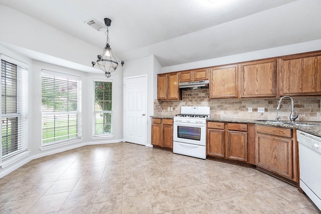 9911 Pierre Ct, Houston, TX 77089 - kitchen featuring white appliances, brown cabinets, decorative backsplash, dark stone countertops, and decorative light fixtures
