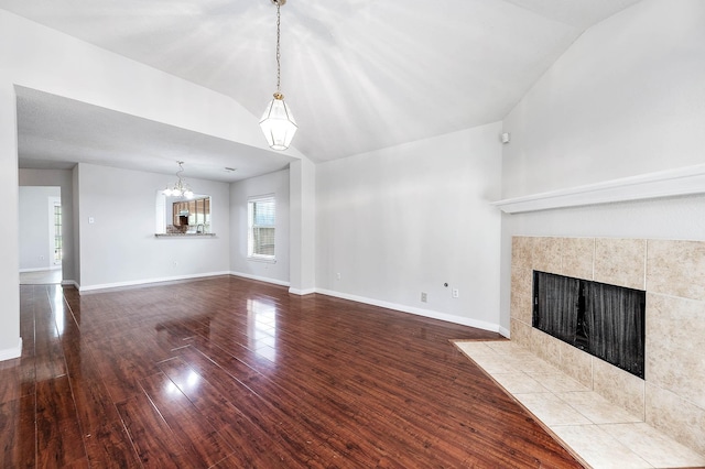 9911 Pierre Ct, Houston, TX 77089 - unfurnished living room with lofted ceiling, a fireplace, wood finished floors, and a chandelier