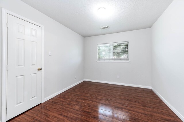 9911 Pierre Ct, Houston, TX 77089 - empty room featuring dark wood-type flooring and a textured ceiling