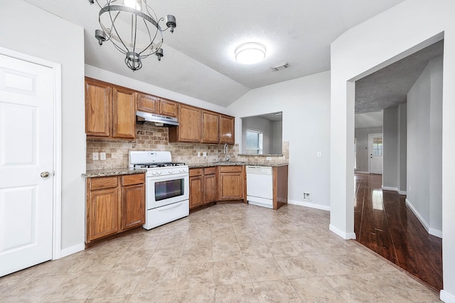 9911 Pierre Ct, Houston, TX 77089 - kitchen with white appliances, under cabinet range hood, brown cabinetry, tasteful backsplash, and lofted ceiling