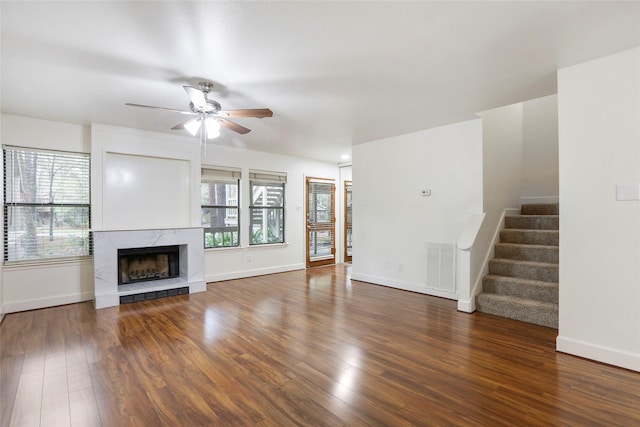 28 Sawmill Grove Ln, The Woodlands, TX 77380 - unfurnished living room featuring a ceiling fan, stairway, wood finished floors, and a high end fireplace