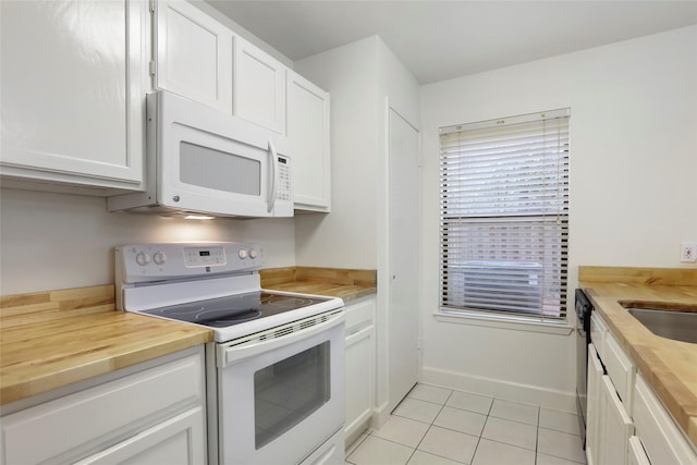 28 Sawmill Grove Ln, The Woodlands, TX 77380 - kitchen with white appliances, butcher block countertops, light tile patterned flooring, and white cabinetry