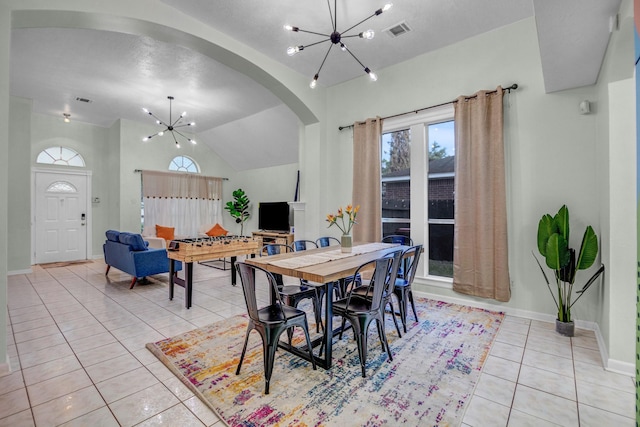 8222 Viny Ridge Dr, Houston, TX 77083 - dining space featuring a chandelier, light tile patterned flooring, arched walkways, and vaulted ceiling