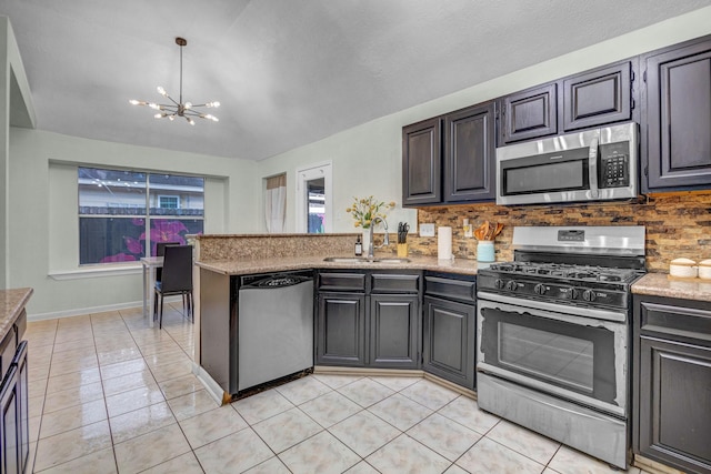 8222 Viny Ridge Dr, Houston, TX 77083 - kitchen with appliances with stainless steel finishes, a chandelier, tasteful backsplash, a peninsula, and light tile patterned floors