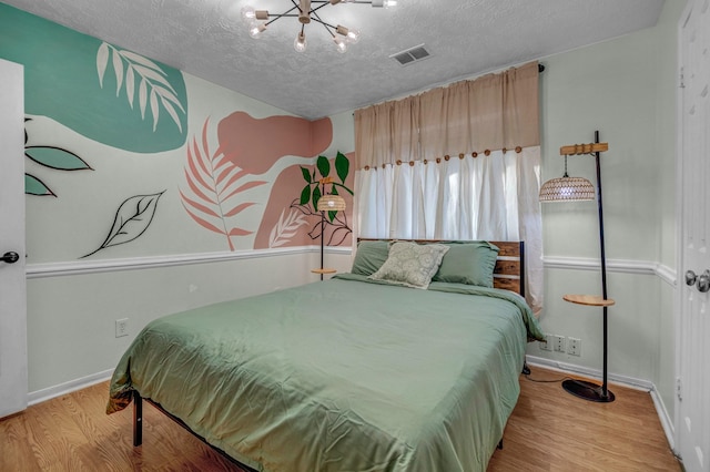 8222 Viny Ridge Dr, Houston, TX 77083 - bedroom with a chandelier, wood finished floors, and a textured ceiling