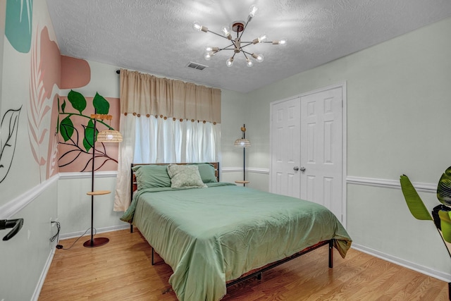 8222 Viny Ridge Dr, Houston, TX 77083 - bedroom with a chandelier, wood finished floors, a textured ceiling, and a closet