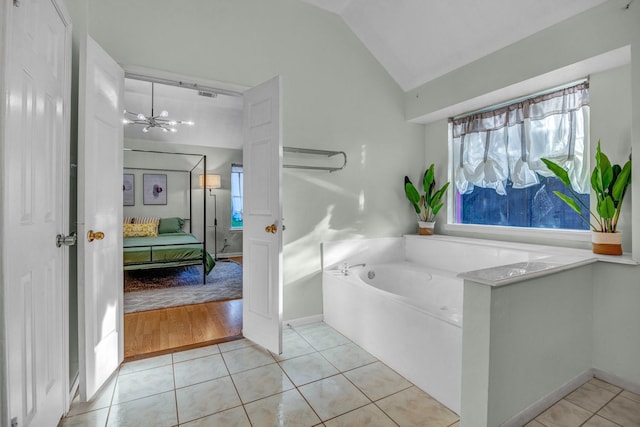 8222 Viny Ridge Dr, Houston, TX 77083 - ensuite bathroom featuring a garden tub, a chandelier, vaulted ceiling, tile patterned floors, and plenty of natural light