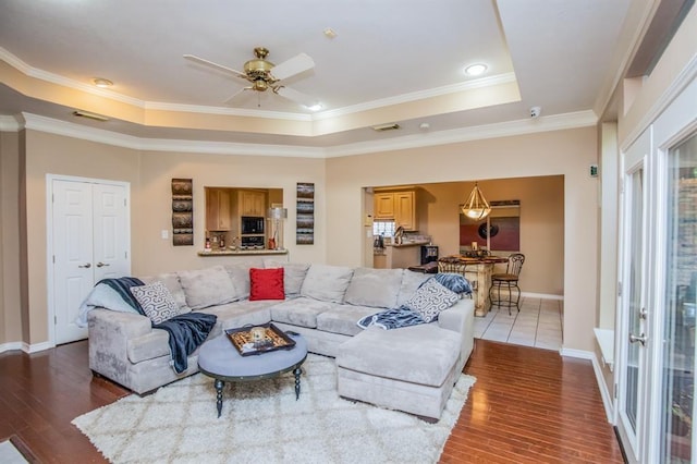6242 Agassi Ace Ct, Spring, TX 77379 - living room featuring a tray ceiling, wood-type flooring, ornamental molding, and a ceiling fan