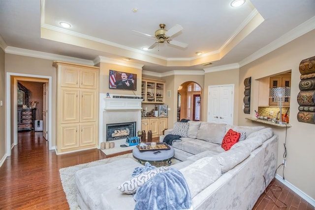 6242 Agassi Ace Ct, Spring, TX 77379 - living area with a raised ceiling, arched walkways, ceiling fan, wood finished floors, and a fireplace
