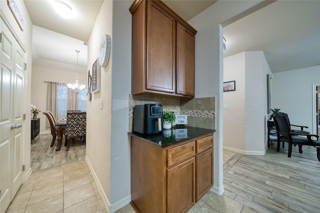 4719 Echo Bay Dr, Baytown, TX 77523 - kitchen with a chandelier, brown cabinets, tasteful backsplash, and light wood-style floors