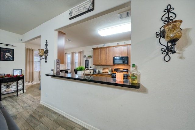 4719 Echo Bay Dr, Baytown, TX 77523 - kitchen featuring black appliances, dark countertops, and brown cabinets