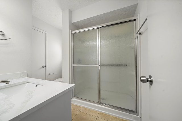 1517 Van Buren Dr, Deer Park, TX 77536 - bathroom featuring a shower stall, vanity, tile patterned flooring, and a textured ceiling