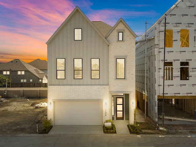 1706 Sedola Ln, Houston, TX 77055 - view of front facade featuring board and batten siding, brick siding, a garage, and driveway