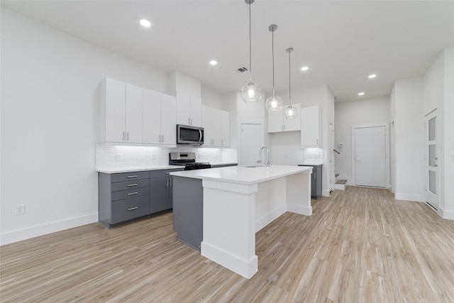2109 Holman, Houston, TX 77004 - kitchen with appliances with stainless steel finishes, gray cabinetry, tasteful backsplash, white cabinets, and light wood-style floors