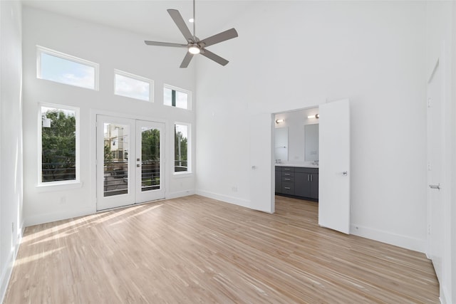 2109 Holman, Houston, TX 77004 - spare room featuring french doors, a towering ceiling, a ceiling fan, and light wood-style flooring