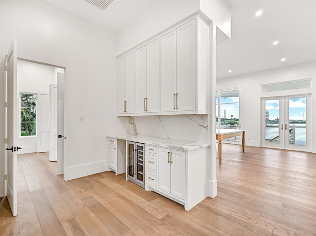 430 81st St, Galveston, TX 77554 - indoor dry bar featuring wine cooler, french doors, light wood finished floors, tasteful backsplash, and recessed lighting