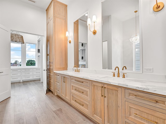 430 81st St, Galveston, TX 77554 - full bath with double vanity, wood finished floors, and a chandelier