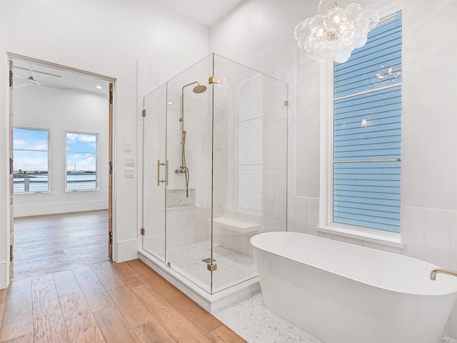 430 81st St, Galveston, TX 77554 - full bath with a freestanding bath, a shower stall, wood finished floors, a chandelier, and recessed lighting