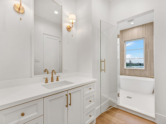 430 81st St, Galveston, TX 77554 - full bathroom featuring vanity, a shower stall, a freestanding bath, and wood finished floors