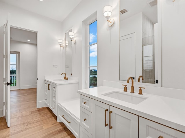 430 81st St, Galveston, TX 77554 - bathroom with two vanities, wood finished floors, and recessed lighting