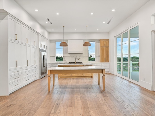430 81st St, Galveston, TX 77554 - kitchen with built in refrigerator, a large island, light wood-style floors, recessed lighting, and a kitchen breakfast bar