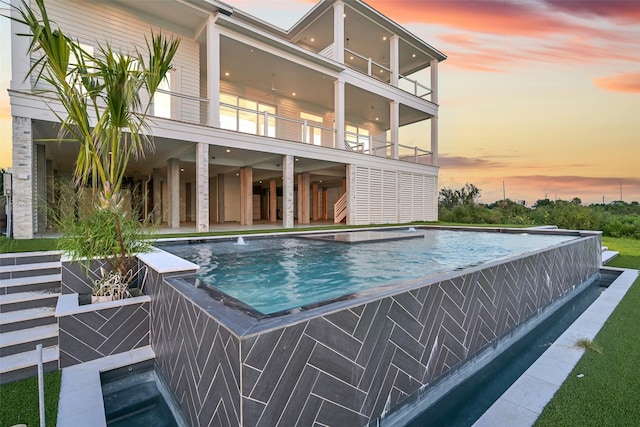 430 81st St, Galveston, TX 77554 - pool at dusk featuring an infinity pool, an outdoor hot tub, a patio, and stairway
