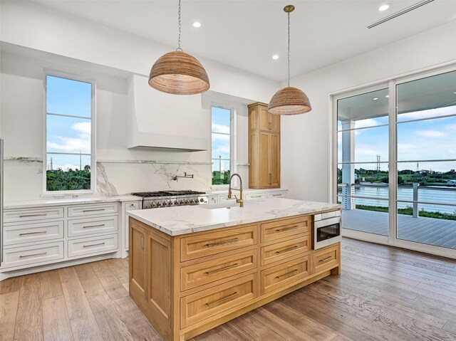 430 81st St, Galveston, TX 77554 - kitchen with backsplash, healthy amount of natural light, light wood finished floors, light stone countertops, and recessed lighting