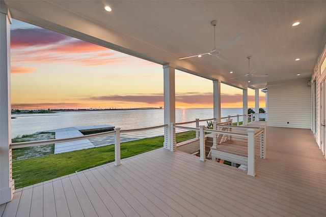 430 81st St, Galveston, TX 77554 - deck at dusk featuring a water view, a ceiling fan, and a lawn