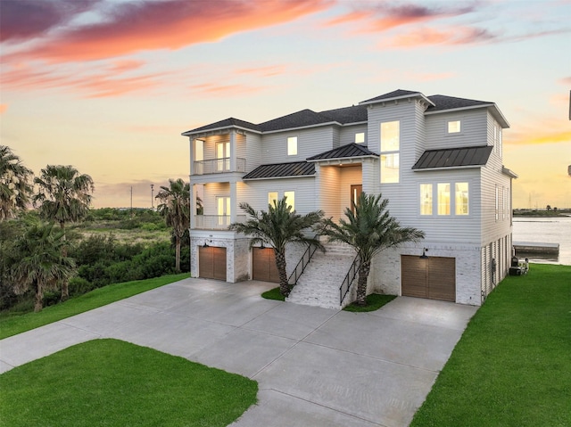 430 81st St, Galveston, TX 77554 - coastal inspired home with a balcony, an attached garage, driveway, and a standing seam roof
