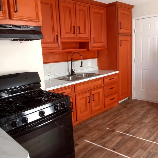 7924 Elvera St, Houston, TX 77012 - kitchen with black gas stove, under cabinet range hood, light countertops, and brown cabinets