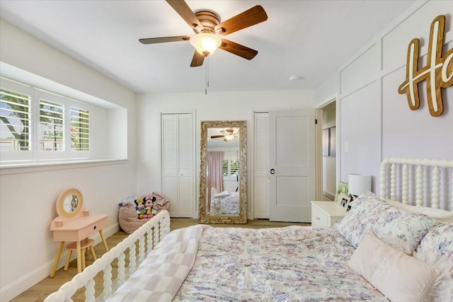 3220 Patricia Ln, Pearland, TX 77581 - bedroom featuring multiple closets, a ceiling fan, and wood finished floors