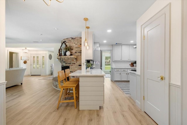 3220 Patricia Ln, Pearland, TX 77581 - kitchen with light wood-type flooring, open floor plan, tasteful backsplash, light countertops, and a peninsula