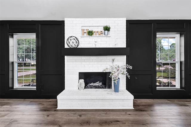 28207 Nancy Ln, Conroe, TX 77385 - unfurnished living room with a decorative wall, a brick fireplace, and wood finished floors