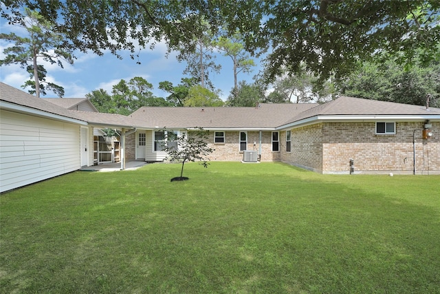 28207 Nancy Ln, Conroe, TX 77385 - back of property featuring a lawn, brick siding, roof with shingles, and a patio