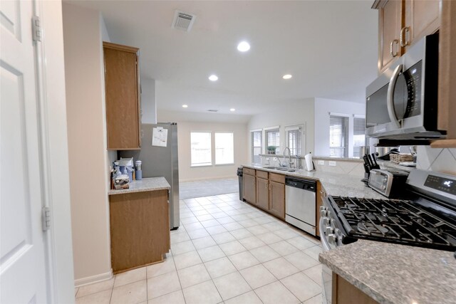 20710 Wagon Bridge Ln, Cypress, TX 77433 - kitchen with appliances with stainless steel finishes, recessed lighting, light tile patterned floors, open floor plan, and a peninsula