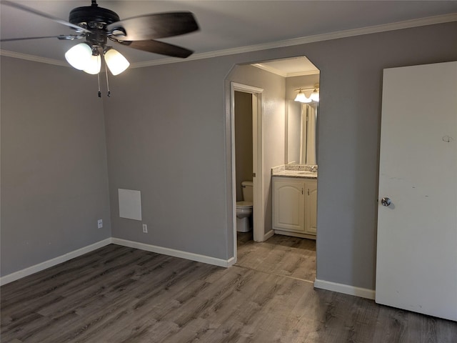 21402 Berry Ridge Ln, Tomball, TX 77375 - unfurnished bedroom featuring wood finished floors, arched walkways, ensuite bathroom, crown molding, and a ceiling fan