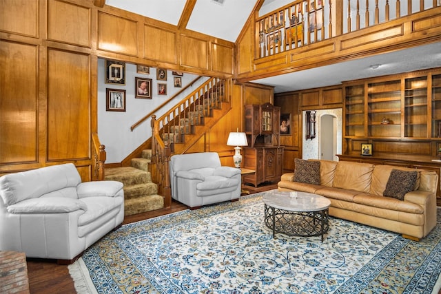 215 Enchanted Estates Dr, Crockett, TX 75835 - living room featuring a towering ceiling, stairway, wood finished floors, wooden walls, and arched walkways
