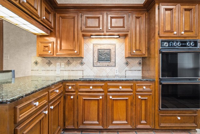 215 Enchanted Estates Dr, Crockett, TX 75835 - kitchen with black appliances, brown cabinetry, backsplash, and dark stone counters