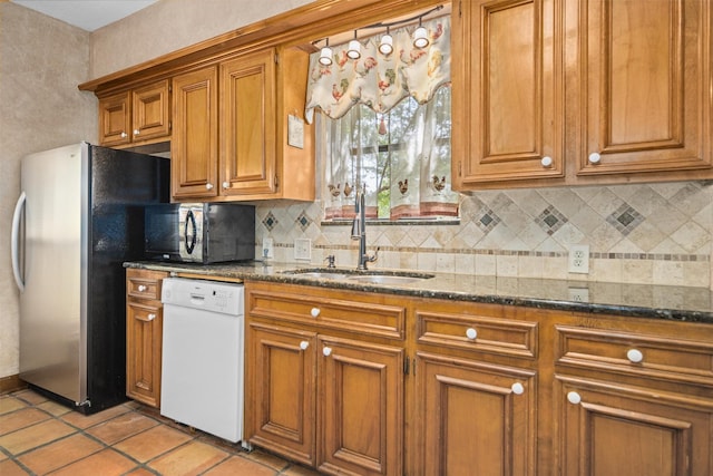 215 Enchanted Estates Dr, Crockett, TX 75835 - kitchen with dishwasher, black microwave, brown cabinets, backsplash, and dark stone counters