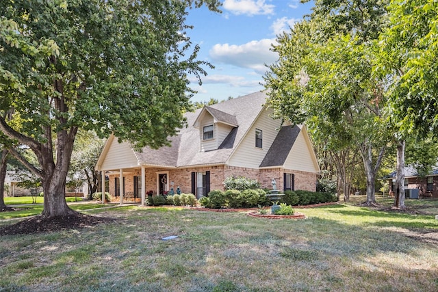 215 Enchanted Estates Dr, Crockett, TX 75835 - cape cod home featuring brick siding, a front yard, covered porch, and a shingled roof