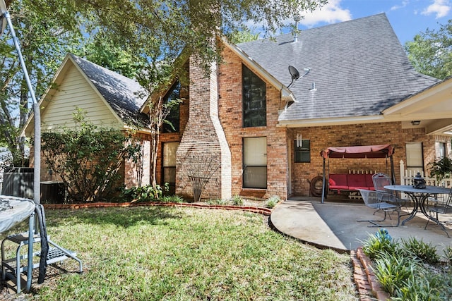 215 Enchanted Estates Dr, Crockett, TX 75835 - back of property with roof with shingles, a chimney, a patio area, a lawn, and brick siding