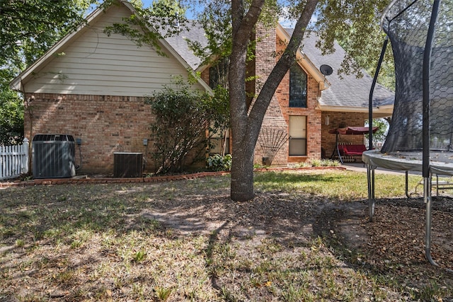 215 Enchanted Estates Dr, Crockett, TX 75835 - rear view of property with a trampoline, brick siding, and a shingled roof