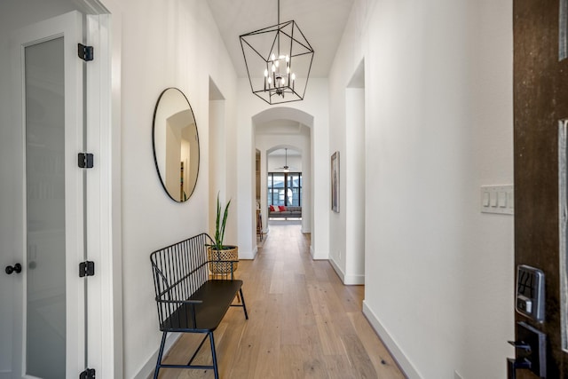 2603 Merlin Way, Katy, TX 77493 - hall featuring arched walkways, light wood-type flooring, and a chandelier
