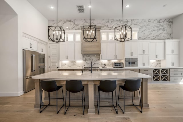 2603 Merlin Way, Katy, TX 77493 - kitchen with high quality fridge, a chandelier, white cabinets, a kitchen bar, and recessed lighting