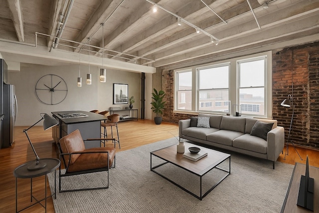201 Main St Unit 5D, Houston, TX 77002 - living area with track lighting, brick wall, wood finished floors, and beam ceiling