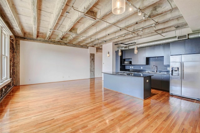 201 Main St Unit 5D, Houston, TX 77002 - kitchen with appliances with stainless steel finishes, light wood-style floors, dark countertops, open floor plan, and backsplash