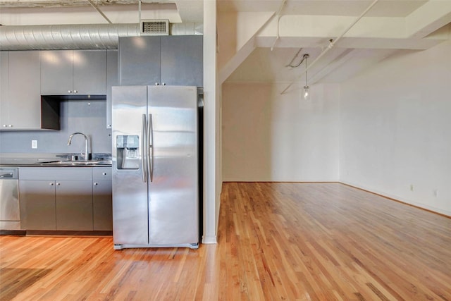 201 Main St Unit 5D, Houston, TX 77002 - kitchen with stainless steel appliances, light wood finished floors, gray cabinets, and dark countertops