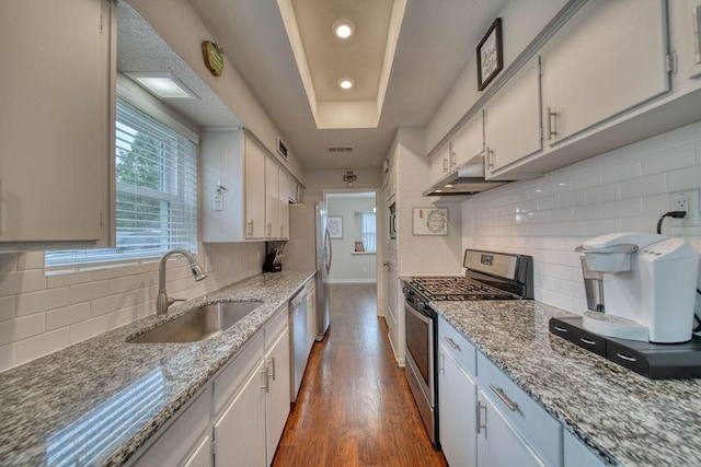 16223 White Star Dr, Houston, TX 77062 - kitchen with stainless steel appliances, tasteful backsplash, under cabinet range hood, dark wood finished floors, and a raised ceiling