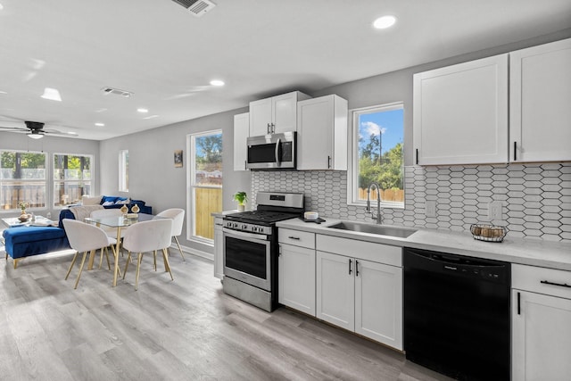 6810 Cohn St, Houston, TX 77091 - kitchen featuring stainless steel appliances, light countertops, recessed lighting, backsplash, and white cabinets