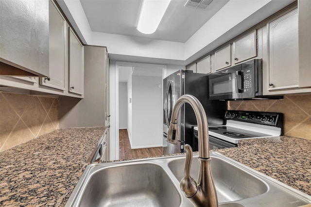 6437 Bayou Glen Rd, Houston, TX 77057 - kitchen featuring black microwave, range with electric cooktop, tasteful backsplash, and dark countertops